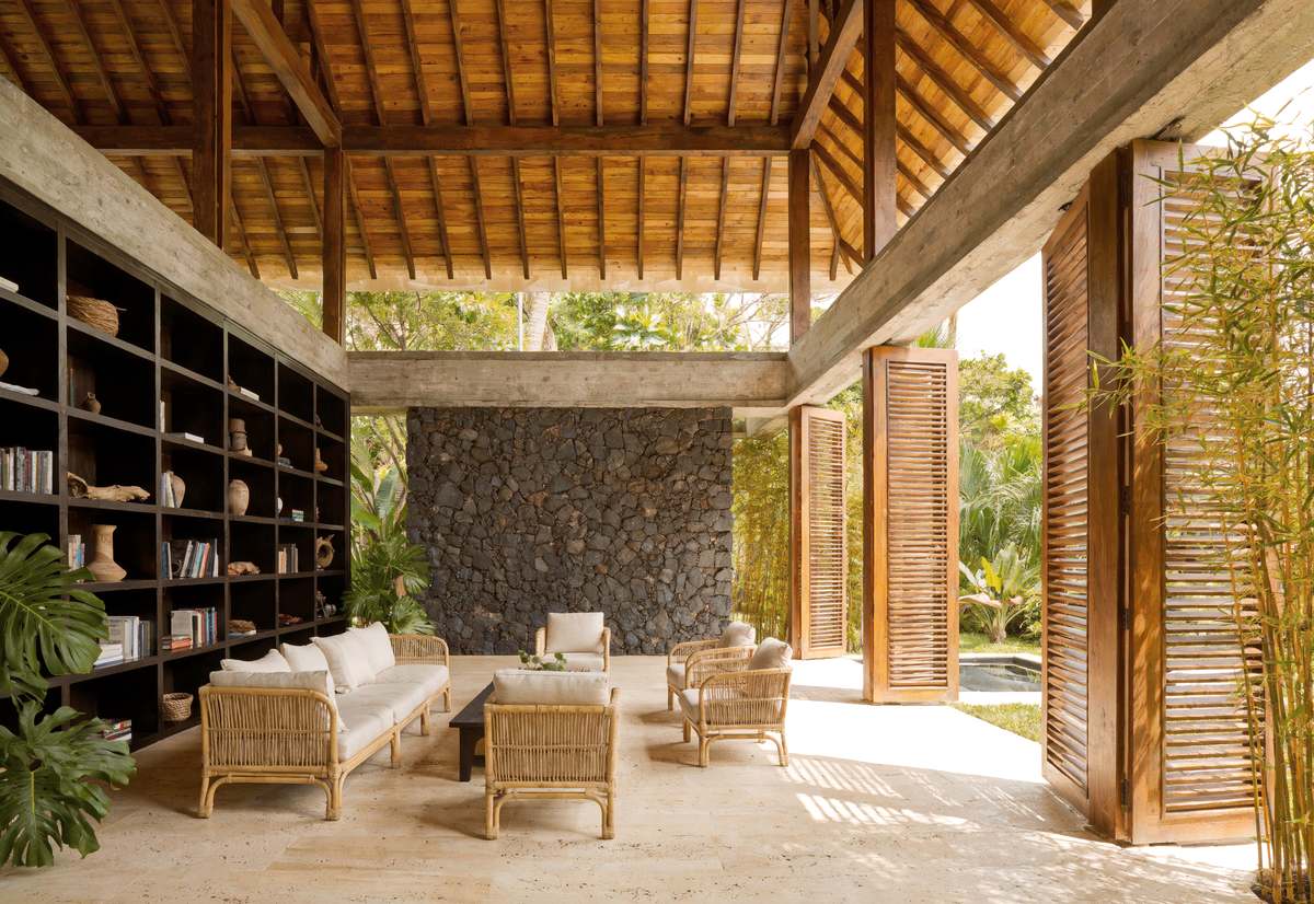 Artist's impression of the lobby: a double-height room open on two sides
                  to the garden, timber ceiling, stone wall, a library wall of dark
                  shelving.